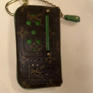 L V Monogram Green and brown Perforated Pochette Clé WalletCoin has corner wear.